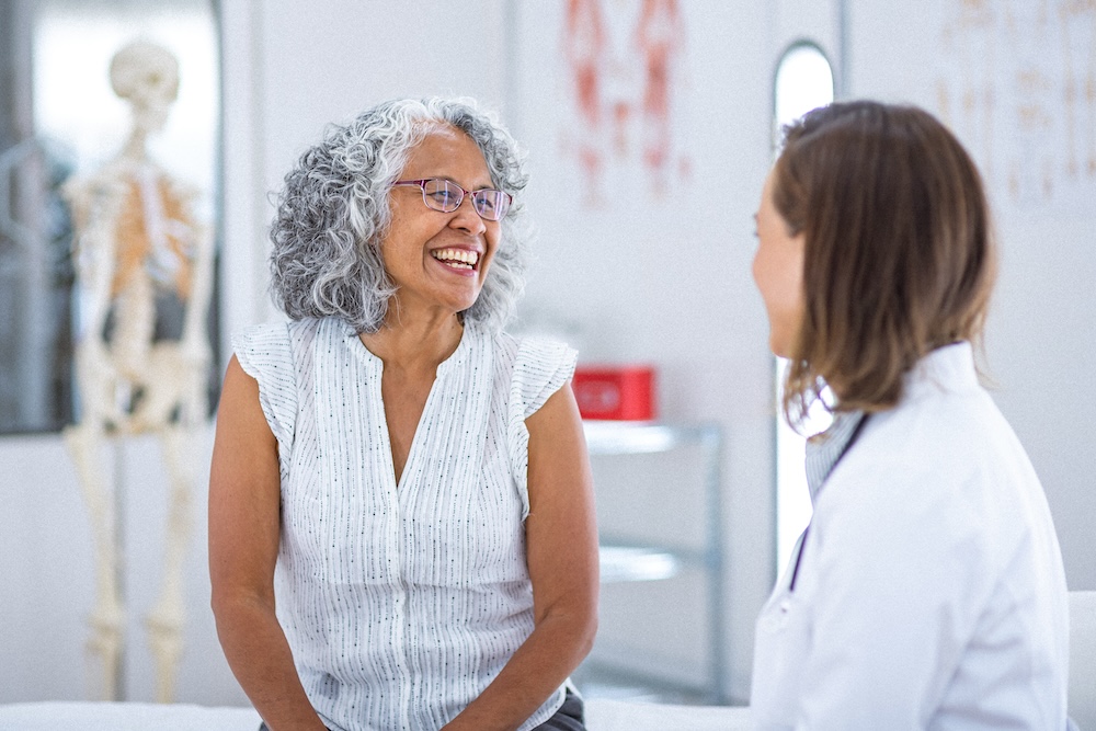 Woman smiling and takling to doctor